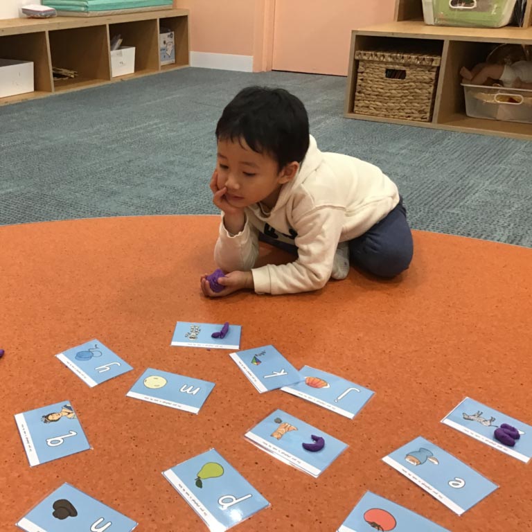 Child with alphabet cards in classroom